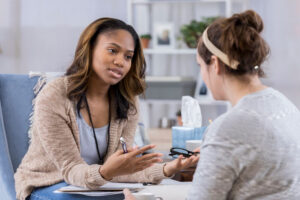 Mental health counselor talking with female patient