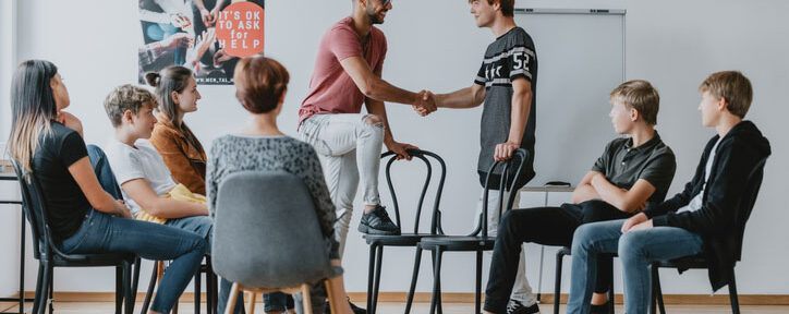 Psychology class meeting in small group shaking hands