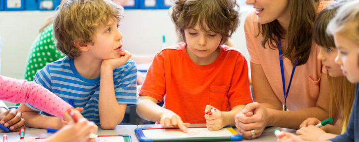 Teaching assistant talking with students in class