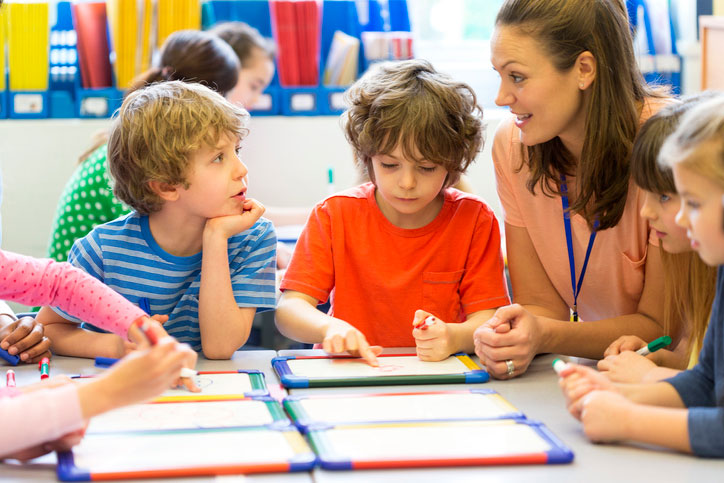 Teaching assistant talking with students in class