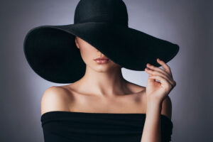 Woman hiding behind brim of hat