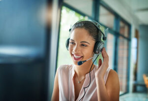 Woman talking on headset at computer screen